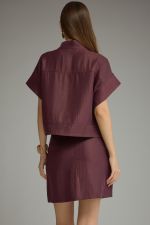 A polished two-piece set featuring a chic cropped top with wide cuffed sleeves paired with a sleek mini skirt for an effortlessly coordinated look.
