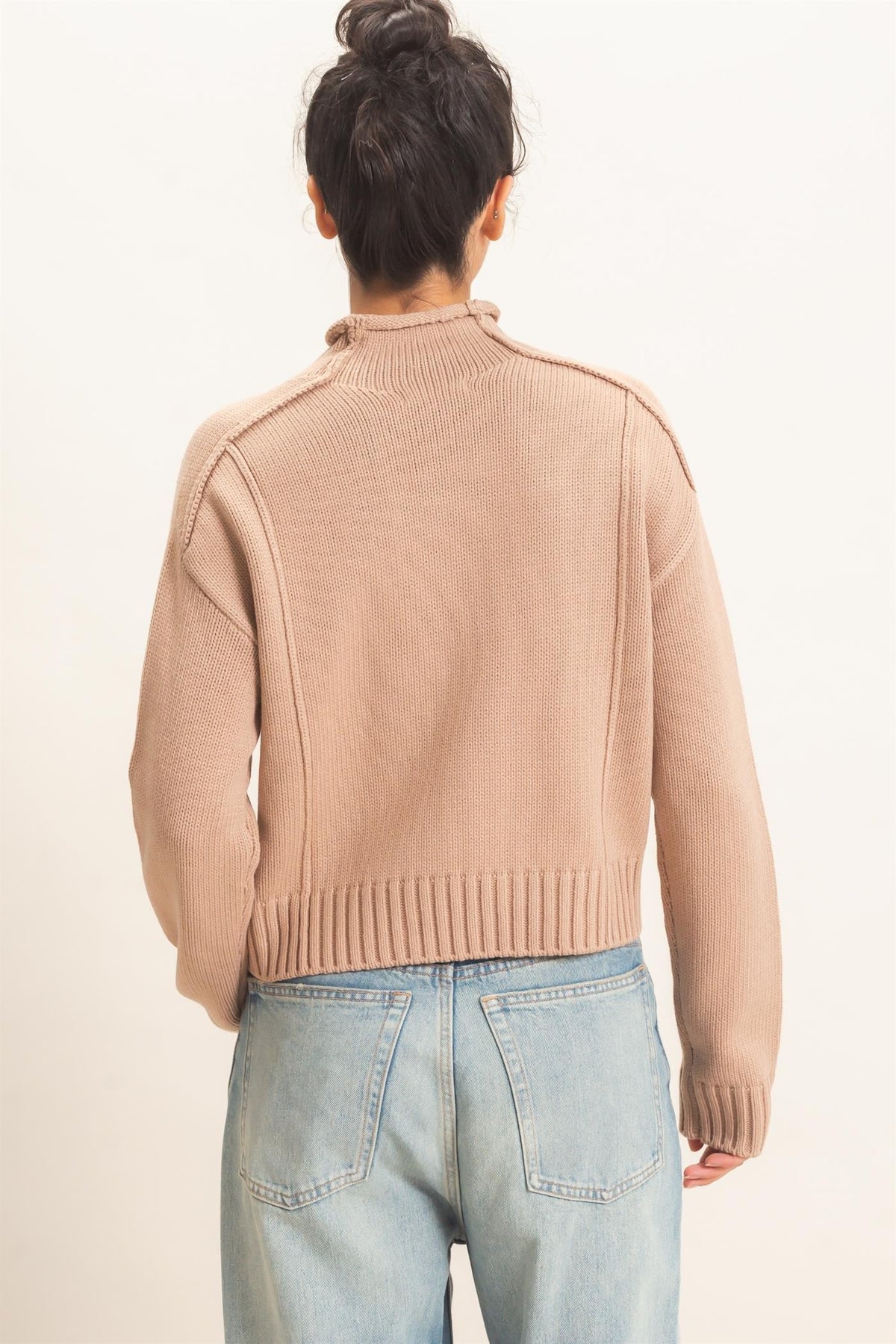A cozy mid-weight roll neck sweater featuring distinctive reverse seam details, ribbed trim, and a relaxed silhouette for effortless everyday style.