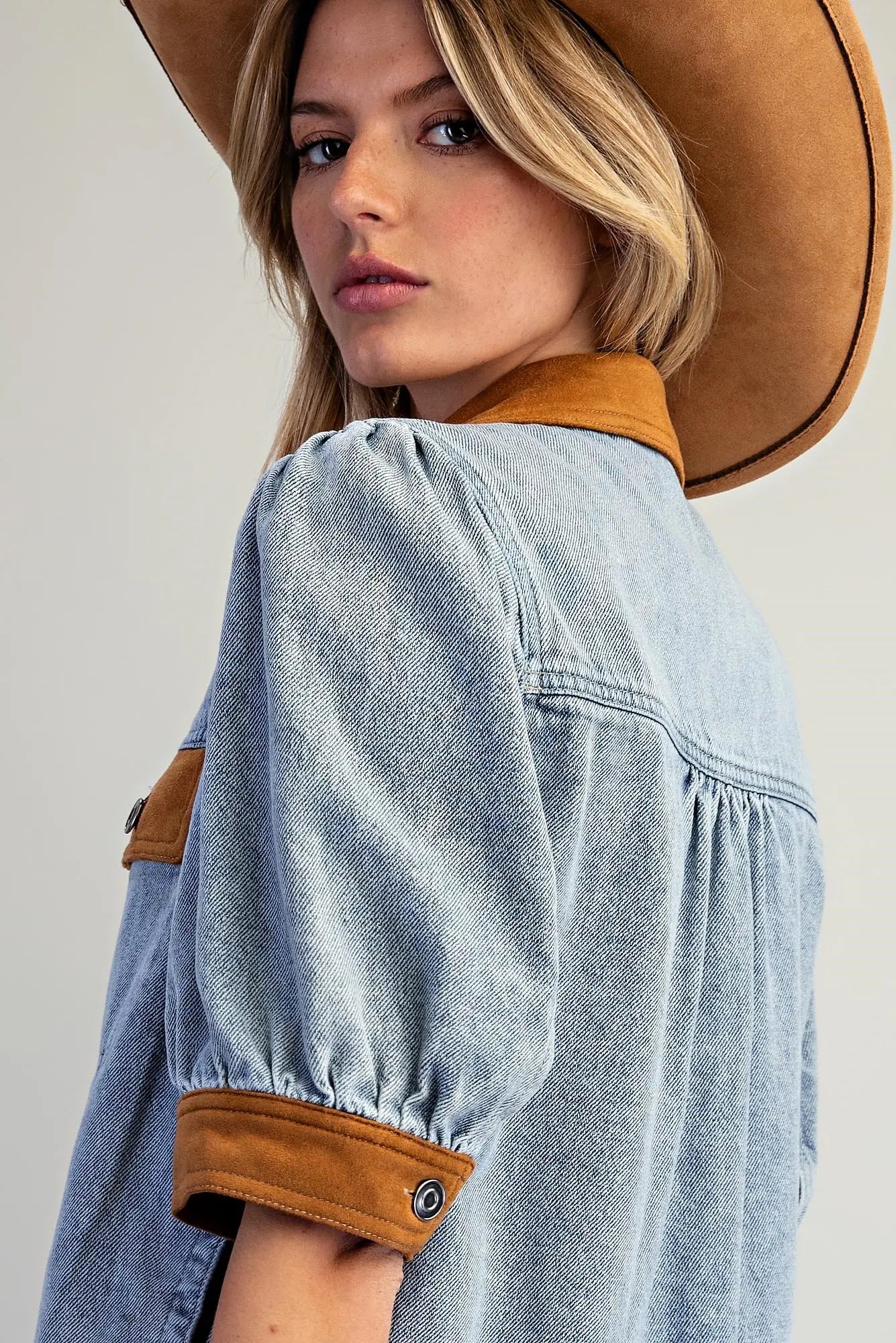 A fashion-forward mineral washed denim jacket accented with camel contrast trim, puff sleeves, and classic metal buttons for an elevated everyday layer.