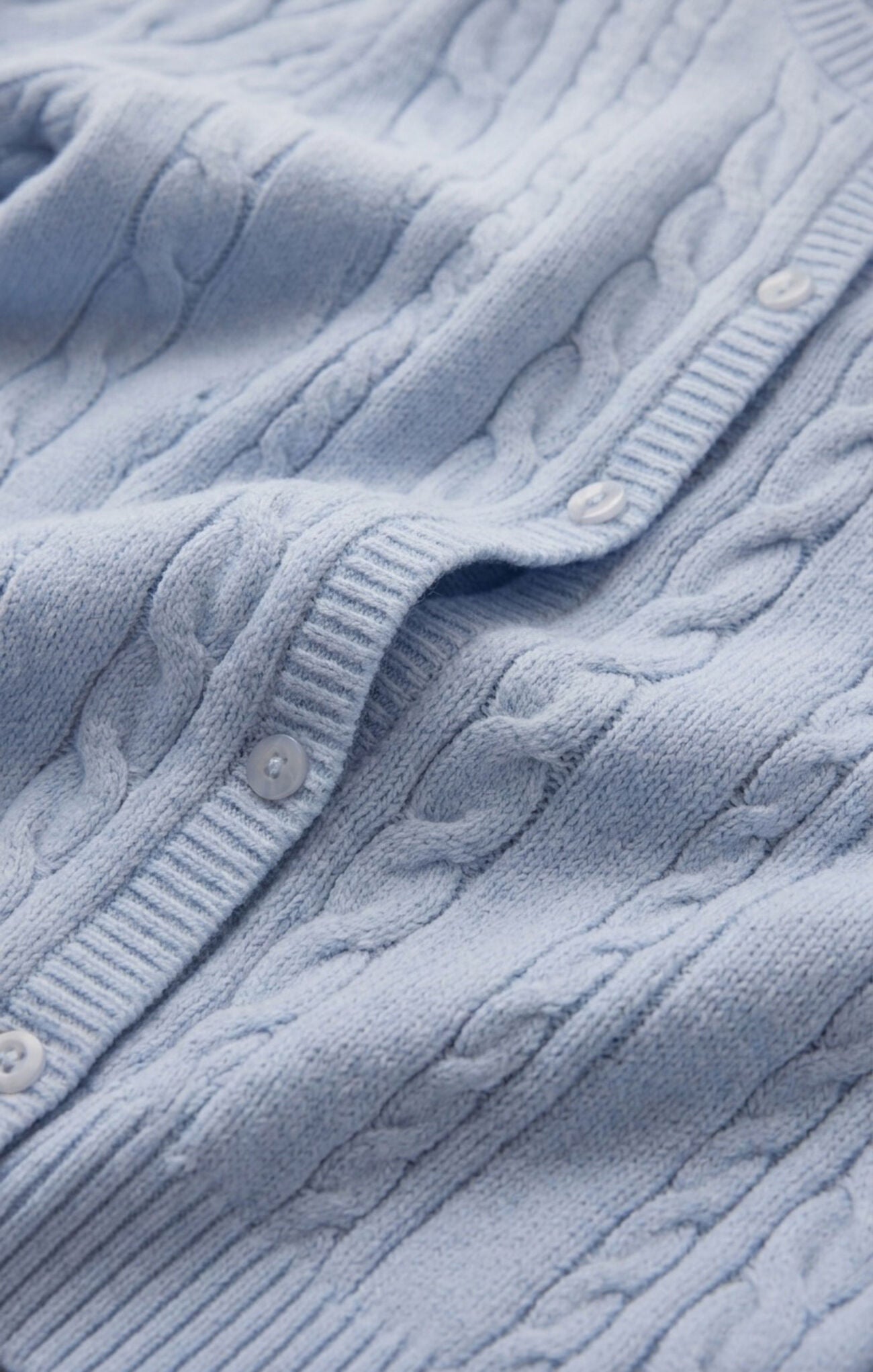 detail of lightweight cable knit button-front top featuring a classic crew neckline