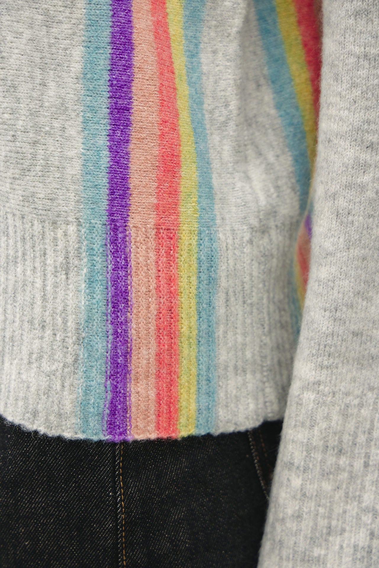 detail of lightweight striped wool blend sweater featuring a soft hand feel, relaxed fit, and vertical rainbow design.