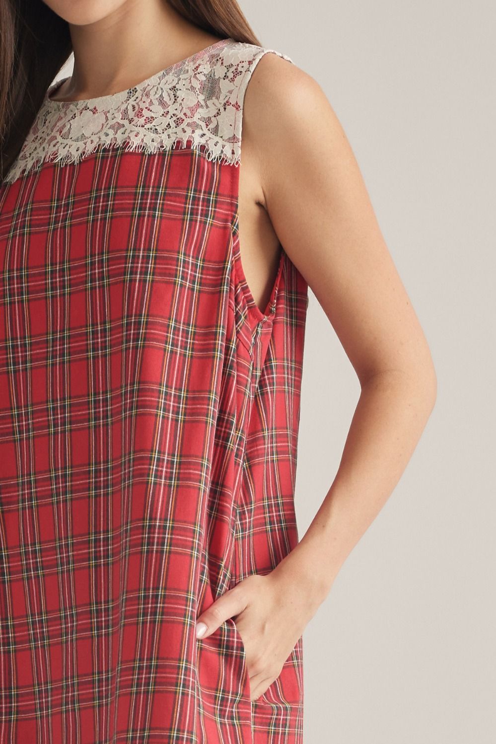 A charming plaid mini dress featuring a delicate lace yoke, lace-trimmed hem, and convenient side pockets for feminine everyday style.