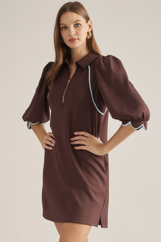 Solid knit mini dress with three-quarter puff sleeves, contrast piping, front zipper, scalloped cuffs, and side pockets
