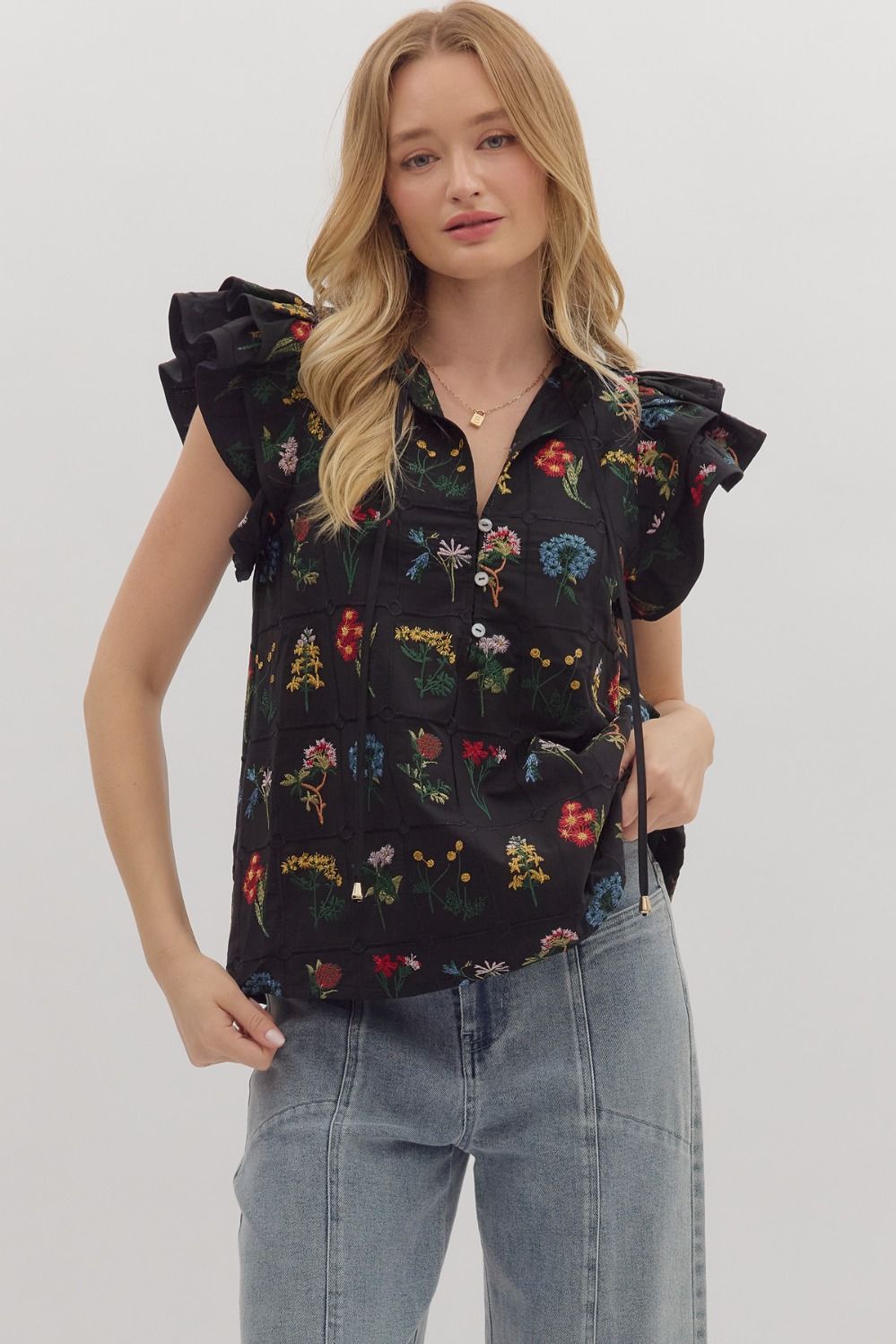 Feminine and lightweight, the Claudette top features flutter sleeves, a tiered silhouette, and a piped split neckline with button detail.