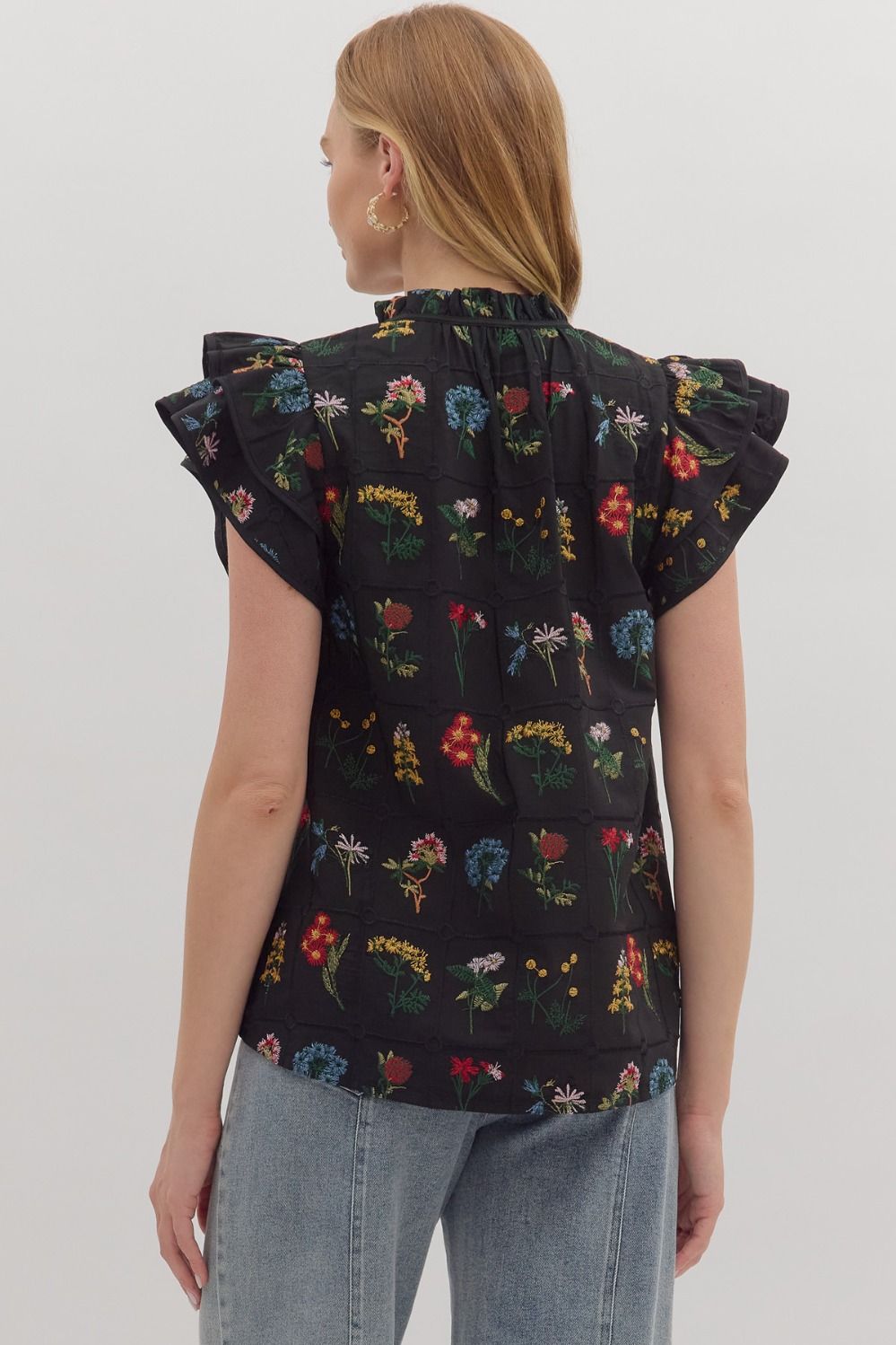 Feminine and lightweight, the Claudette top features flutter sleeves, a tiered silhouette, and a piped split neckline with button detail.