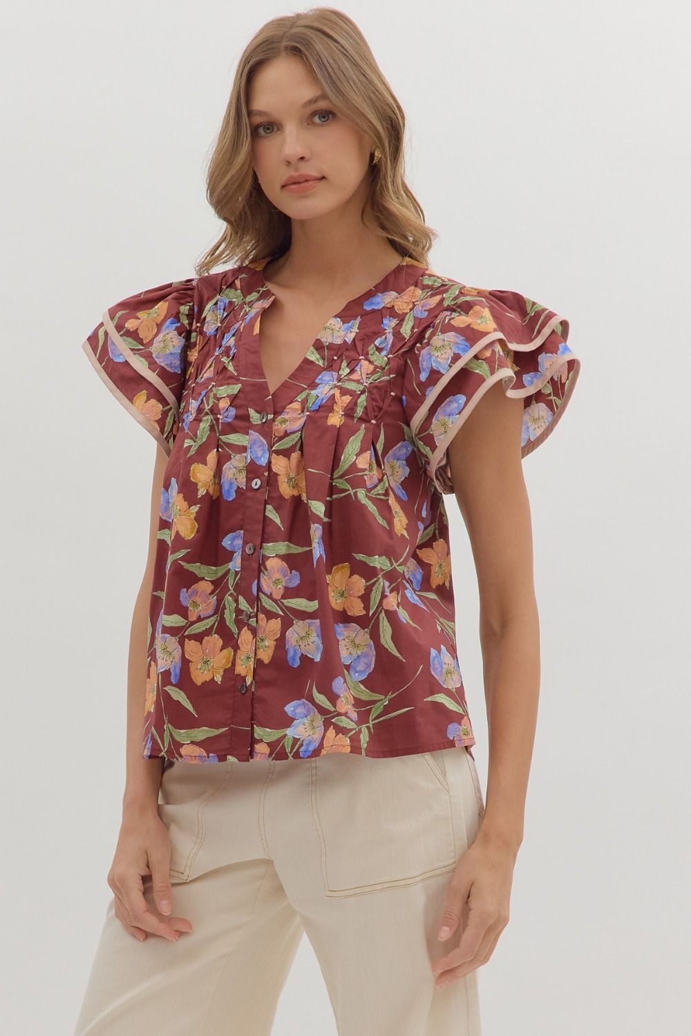 Delicate and airy, the Amelie top features flutter sleeves, pleated details, and contrast binding for feminine charm.