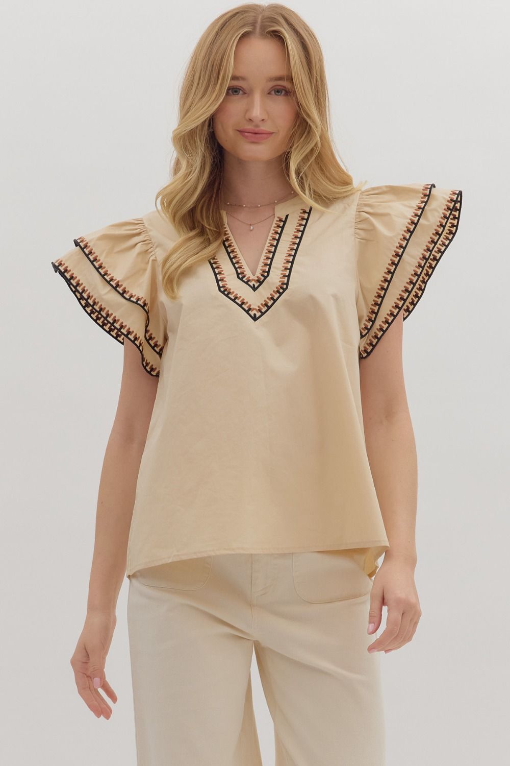 Feminine and breezy, the Odette top features layered flutter sleeves, a V-neck, and contrast embroidered trim for a polished finish.