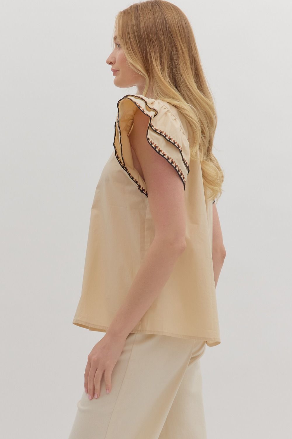 Feminine and breezy, the Odette top features layered flutter sleeves, a V-neck, and contrast embroidered trim for a polished finish.