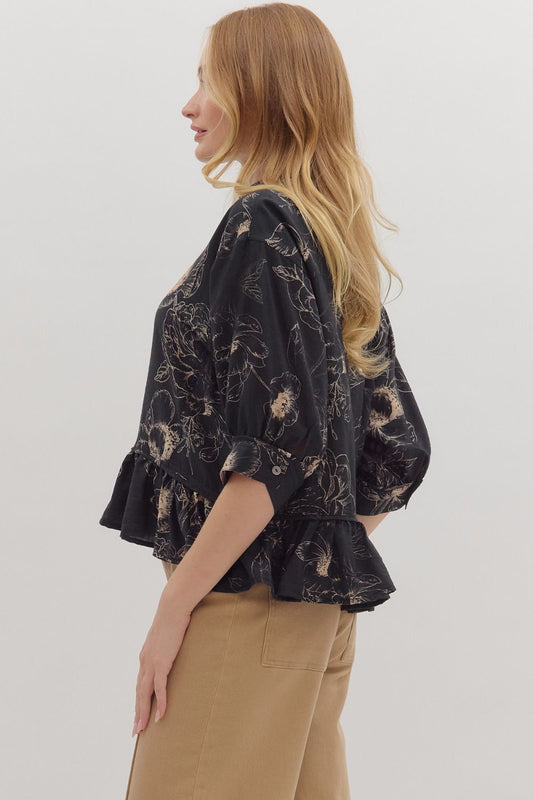 Floral print roll tab 3/4 sleeve high-low top featuring ruffle hem and button closure at front. Button closure at cuff. Unlined. Woven. Non-sheer. Lightweight.