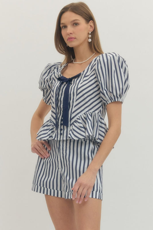 Stripe print puff sleeve peplum top with front self-tie bow detail and fabric-covered buttons.
