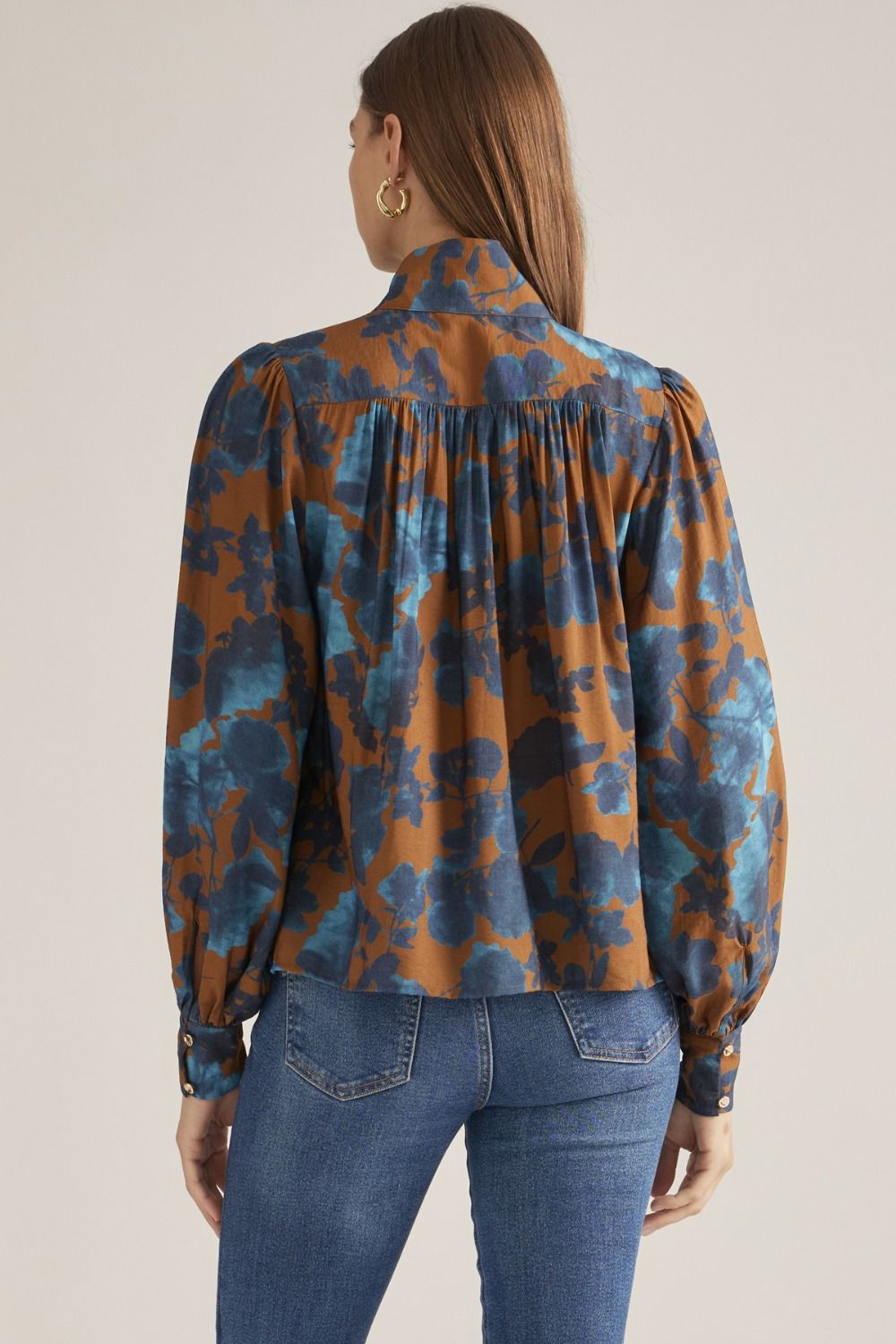 Women's floral woven blouse with stand collar, long puff sleeves, button-front closure, and gathered back yoke