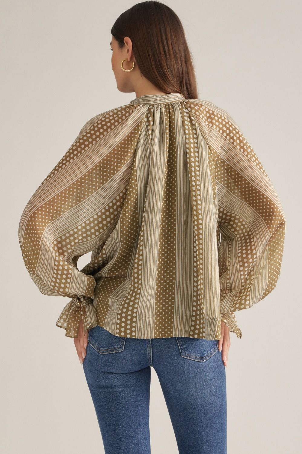 Women's mixed-print blouse featuring striped and polka dot patterns, V-neckline, long puff sleeves, and button-detail cuffs