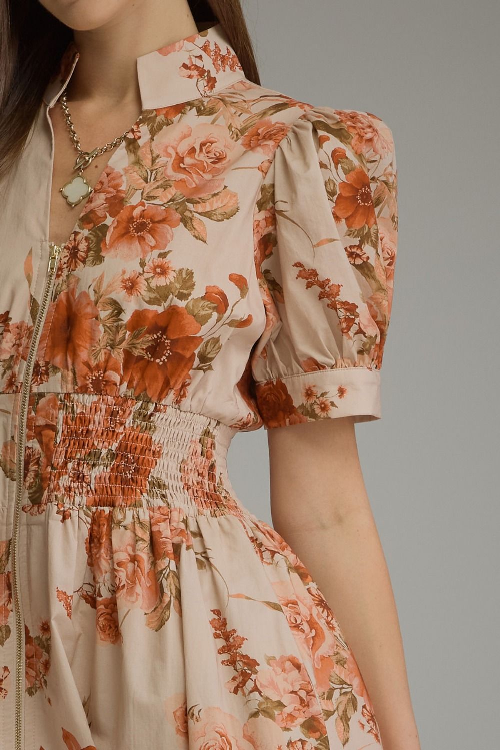 A feminine floral midi dress featuring short puff sleeves, a chic stand collar, a front zipper, and a flattering smocked waist.