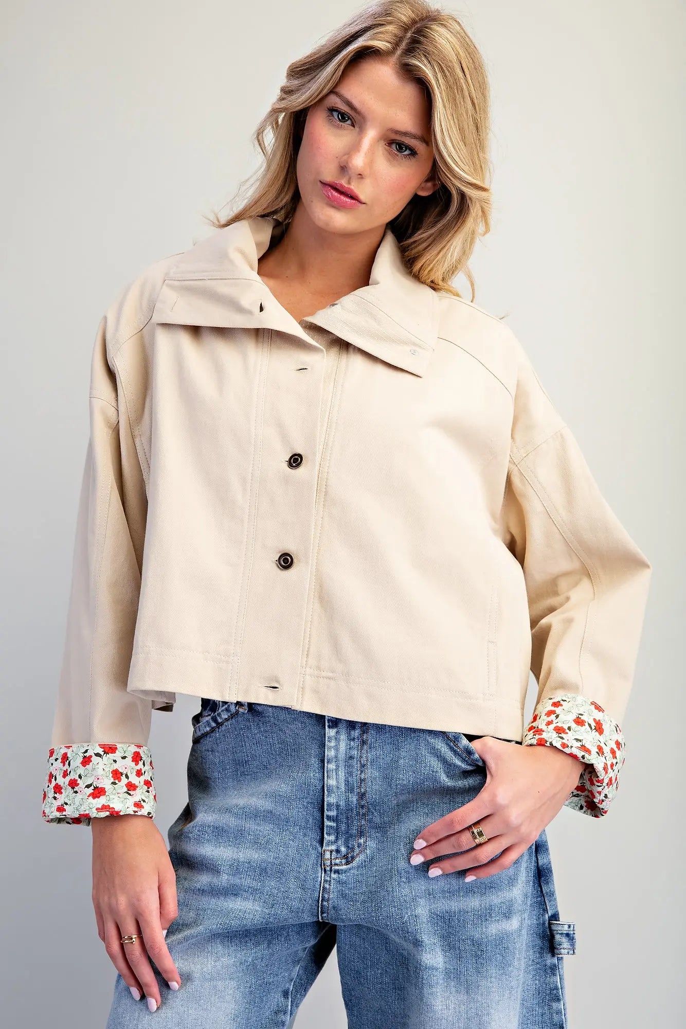 The Marjorie Floral Lined Cropped Jacket pairs a relaxed beige silhouette with a vibrant floral lining for a sophisticated statement layer with a playful twist.