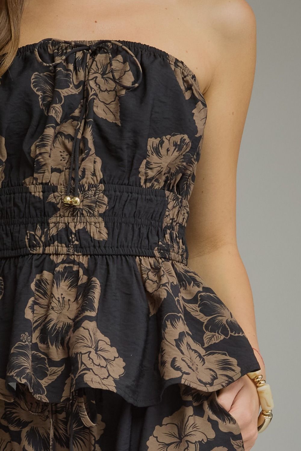 A feminine floral peplum top featuring a straight neckline, adjustable tie straps, smocked waist, and lightweight lined design for effortless summer style.