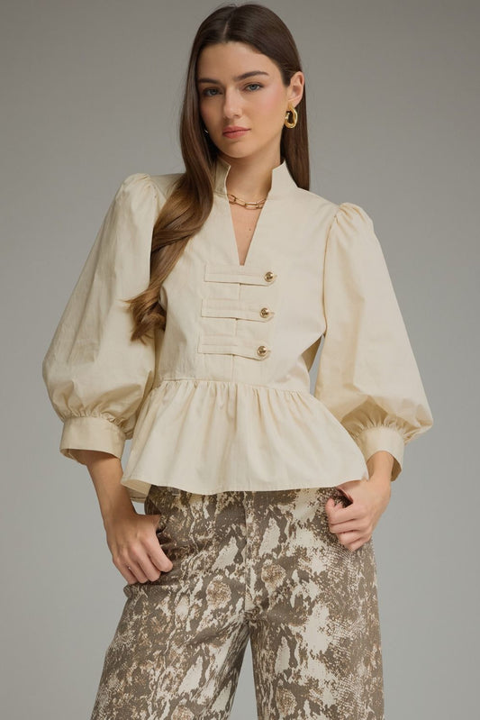 A feminine ¾-sleeve peplum top featuring romantic puff sleeves, a flattering split neckline, and stylish button-tab detailing.
