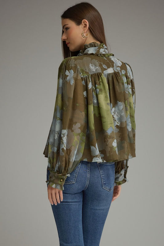 A romantic printed blouse featuring voluminous long sleeves, a ruffled stand collar, feminine button details, and delicate ruffle-trimmed cuffs.