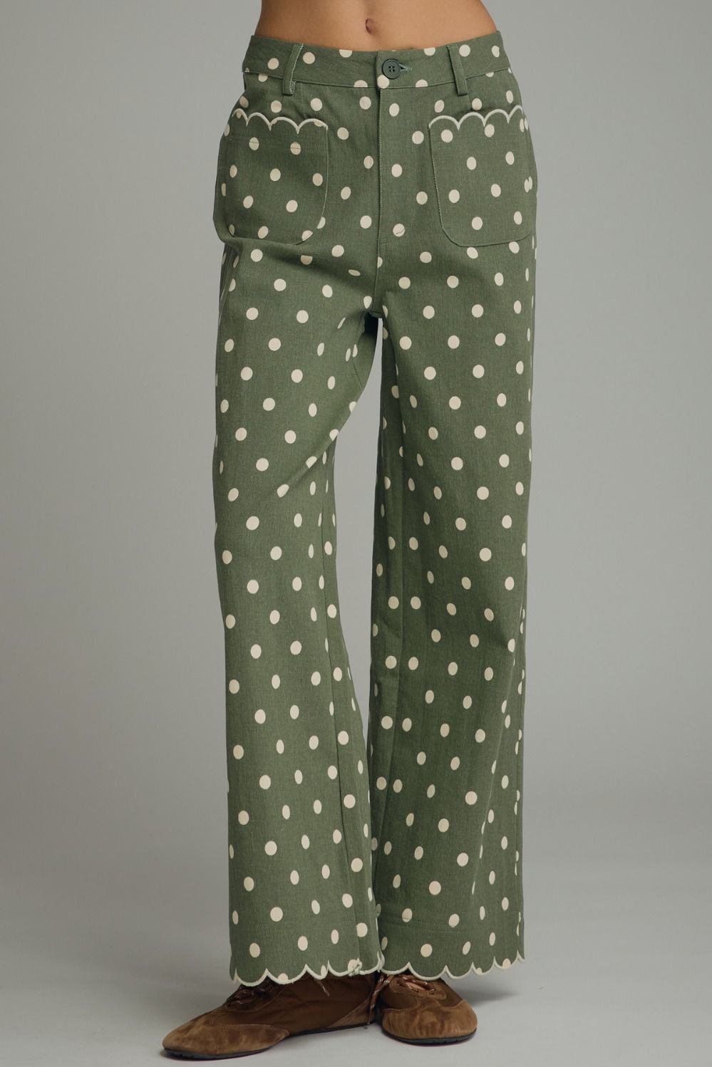 Playful polka dot wide-leg pants featuring scalloped embroidered trim and a polished button-front closure for a feminine, elevated look.