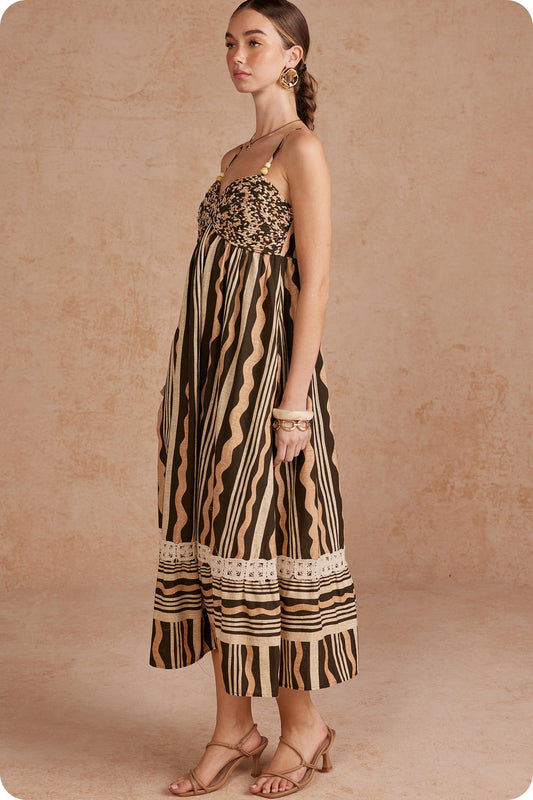 Effortlessly elegant and perfect for sunny days, this printed linen midi dress features delicate braided details and spaghetti straps for a timeless, feminine look.