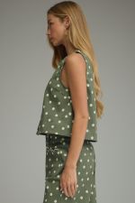 A timeless polka dot sleeveless top with a classic round neckline and button-front detail for effortless everyday style.