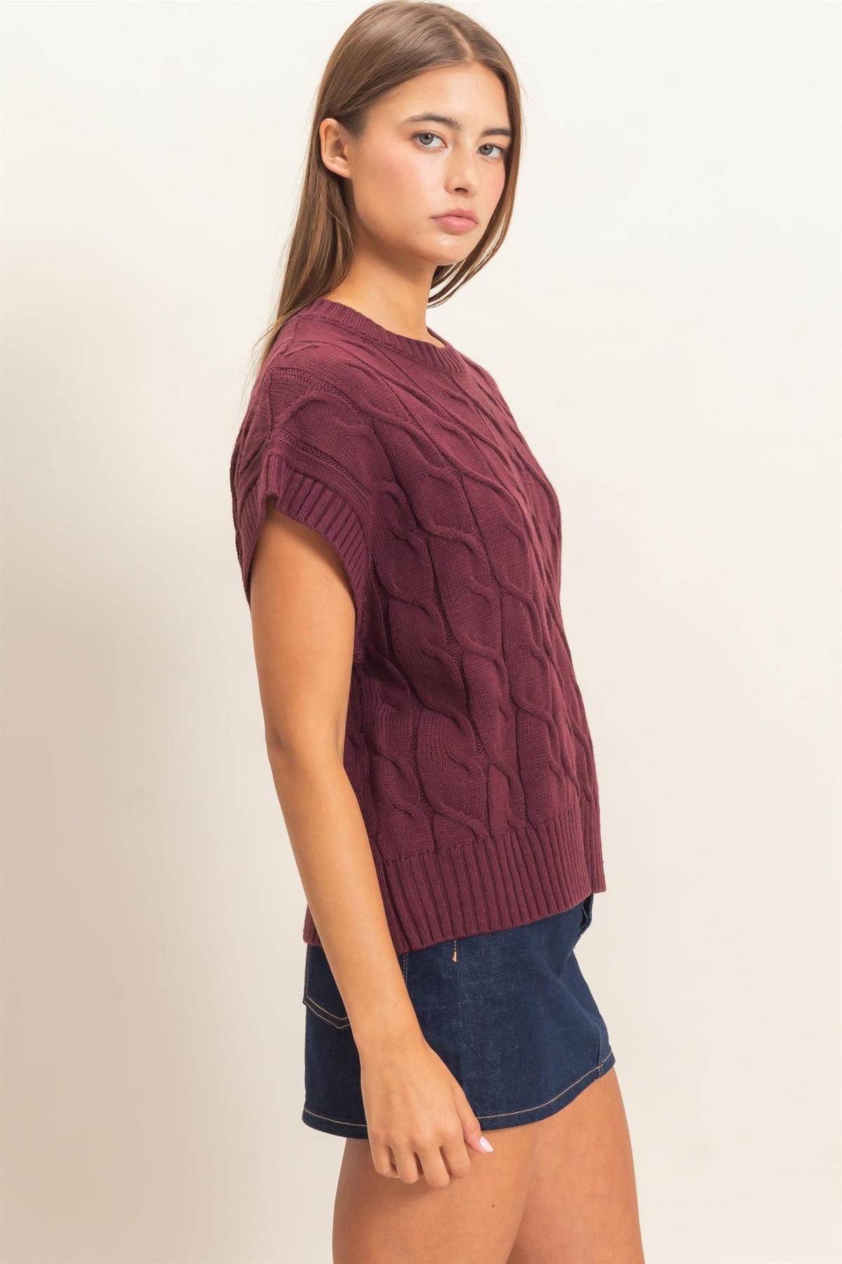 A timeless cable knit sweater featuring a classic crew neckline and cap sleeves for an effortlessly polished look you'll wear year-round.