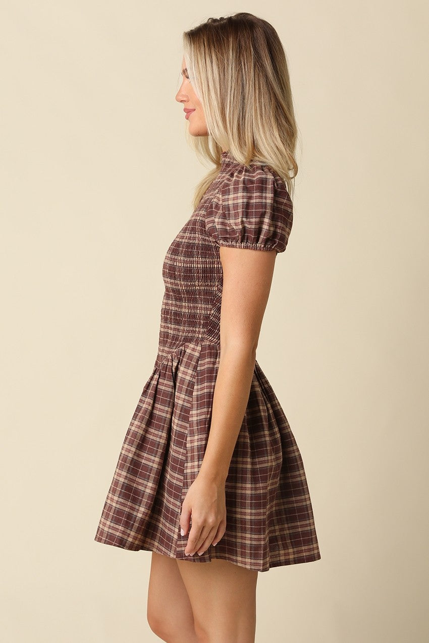 The Rebecca Plaid Smocked Mini Dress pairs timeless plaid with a flattering fit-and-flare silhouette, delicate ruffle sleeves, and a softly gathered skirt.