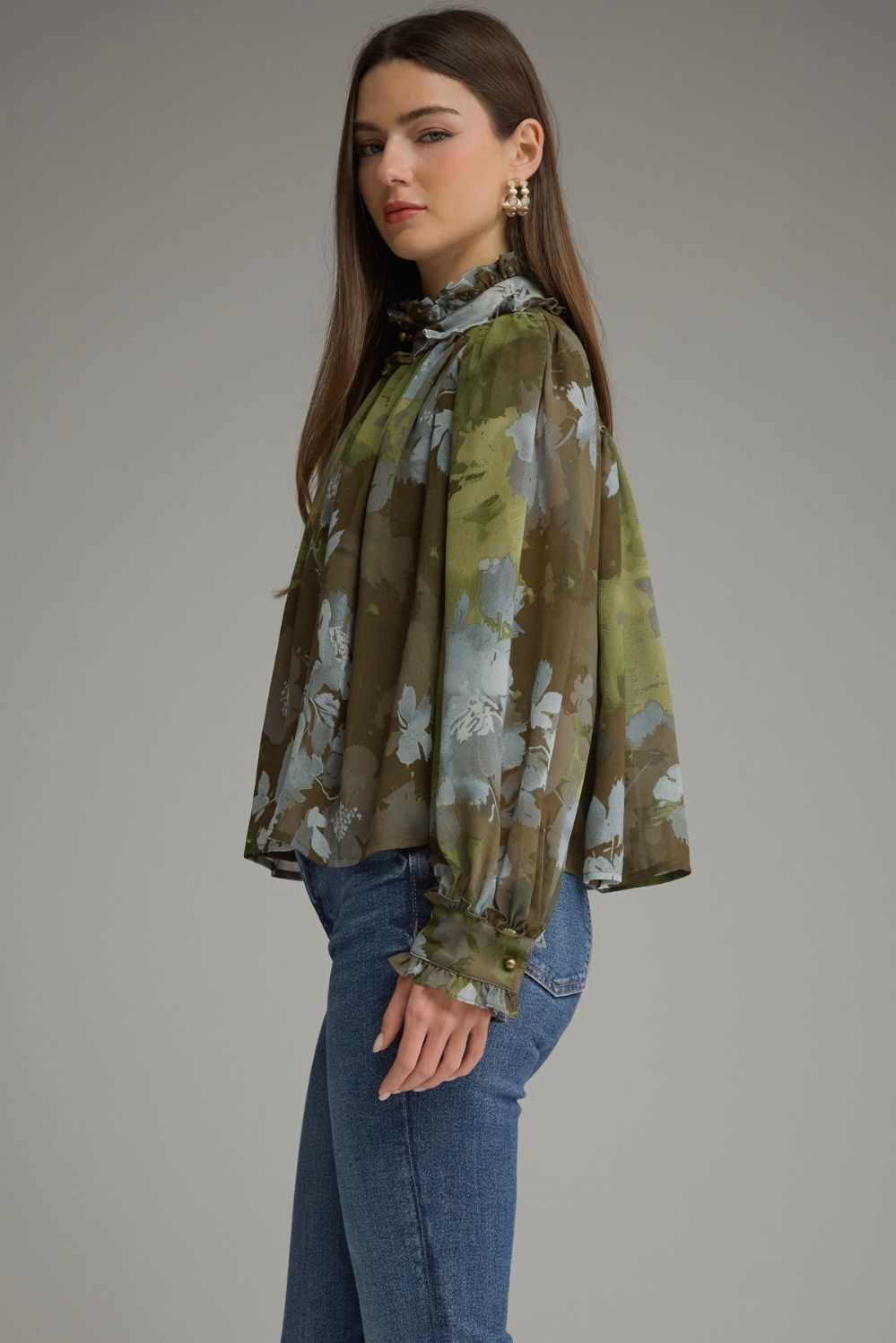 A romantic printed blouse featuring voluminous long sleeves, a ruffled stand collar, feminine button details, and delicate ruffle-trimmed cuffs.