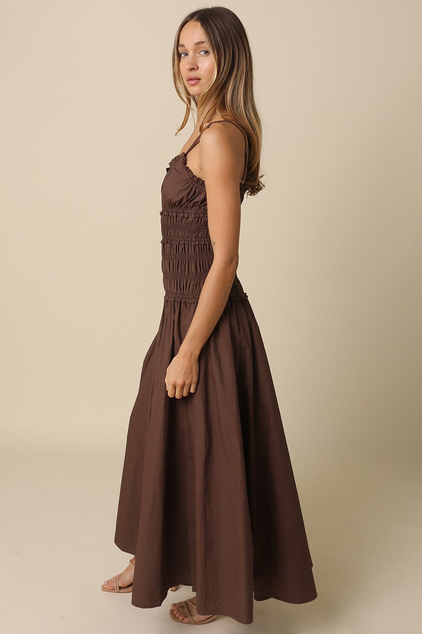 A breezy cotton maxi dress featuring a flattering smocked bodice, front cutout detail, adjustable straps, and a flowy silhouette made for sunny days.
