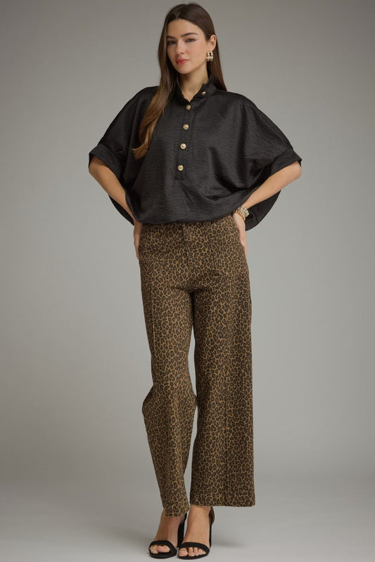 A polished solid short sleeve top featuring a sophisticated stand collar, partial button front, and softly structured cuffed sleeves.