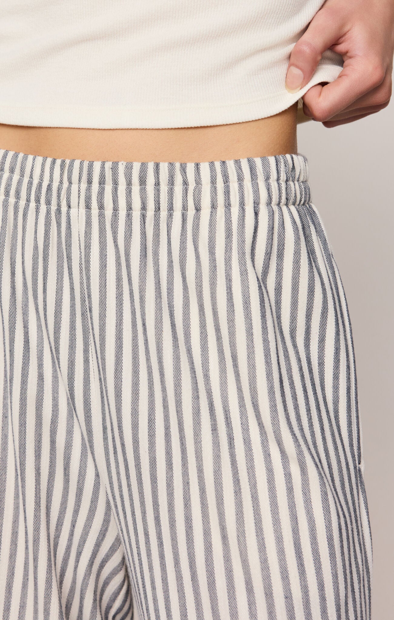 Women’s high-rise wide-leg ankle pants in silky stretch knit fabric with elastic waistband, slash pockets, lightweight design, and ultra-soft finish.