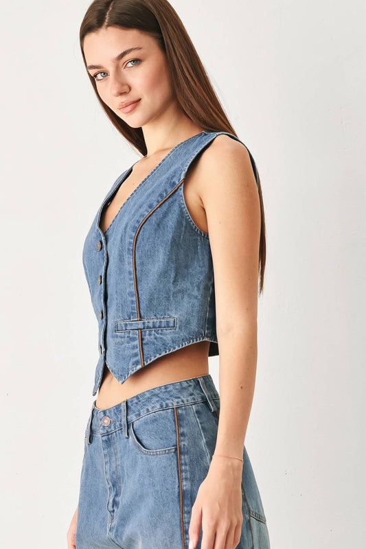 Model wearing the Winslet Washed Denim Vest featuring a washed cotton-blend denim finish, front button closure, tailored fit, and piping detail from Pieces & Peaches boutique.