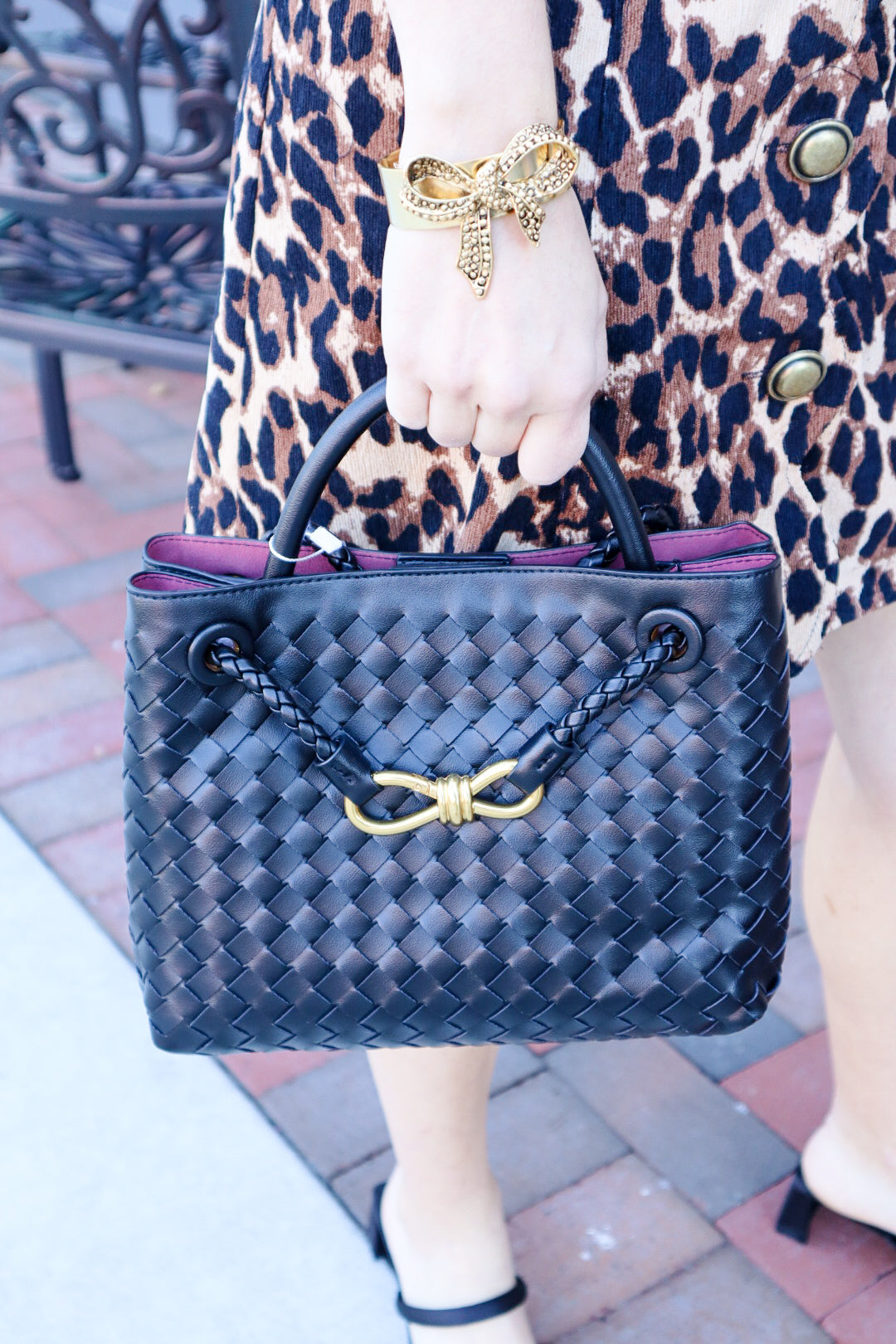 Elegant woven leather tote bag with gold-tone bow hardware and structured handles