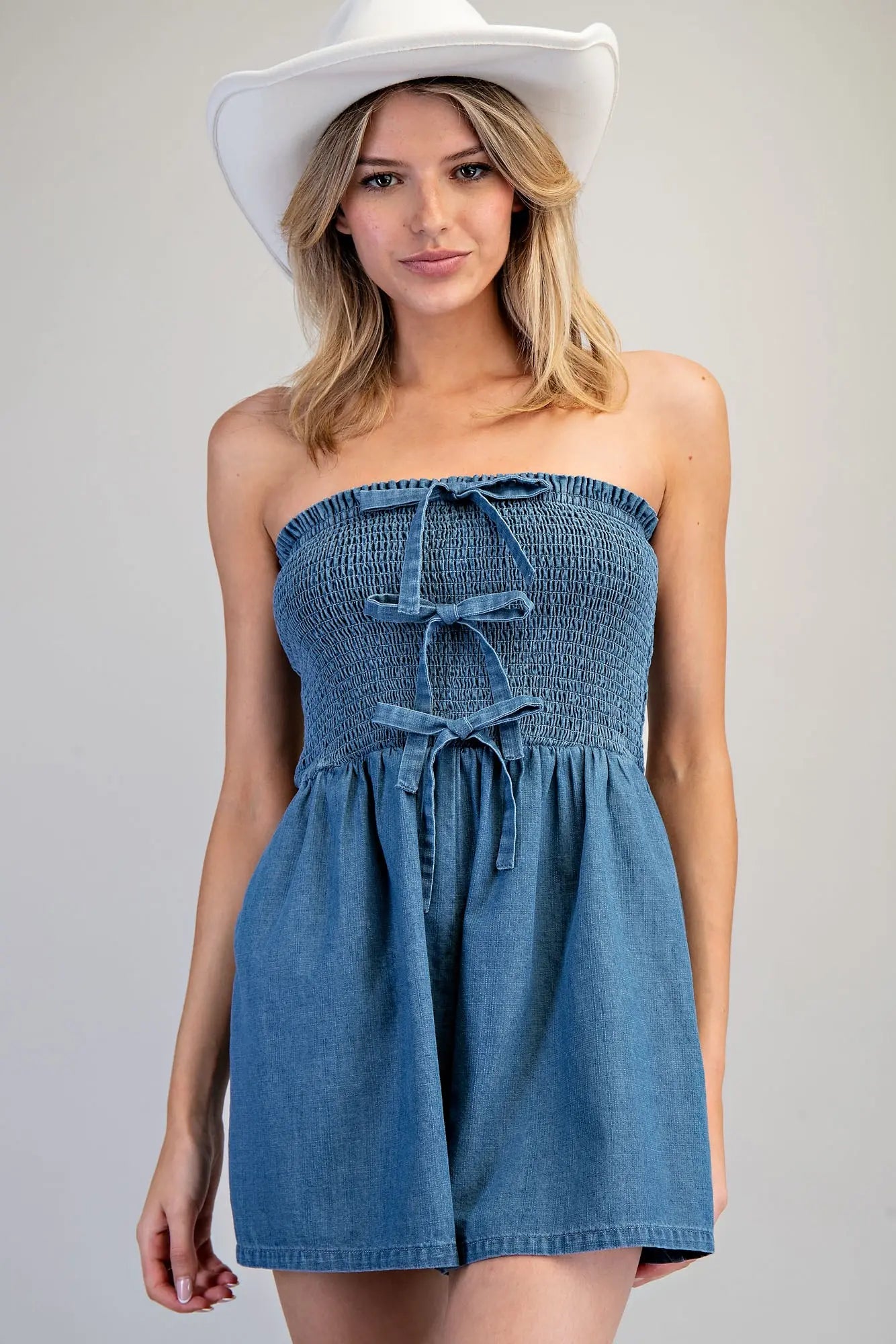 Strapless Front Tie Romper features a smocked bodice with front tie details and relaxed wide-leg shorts