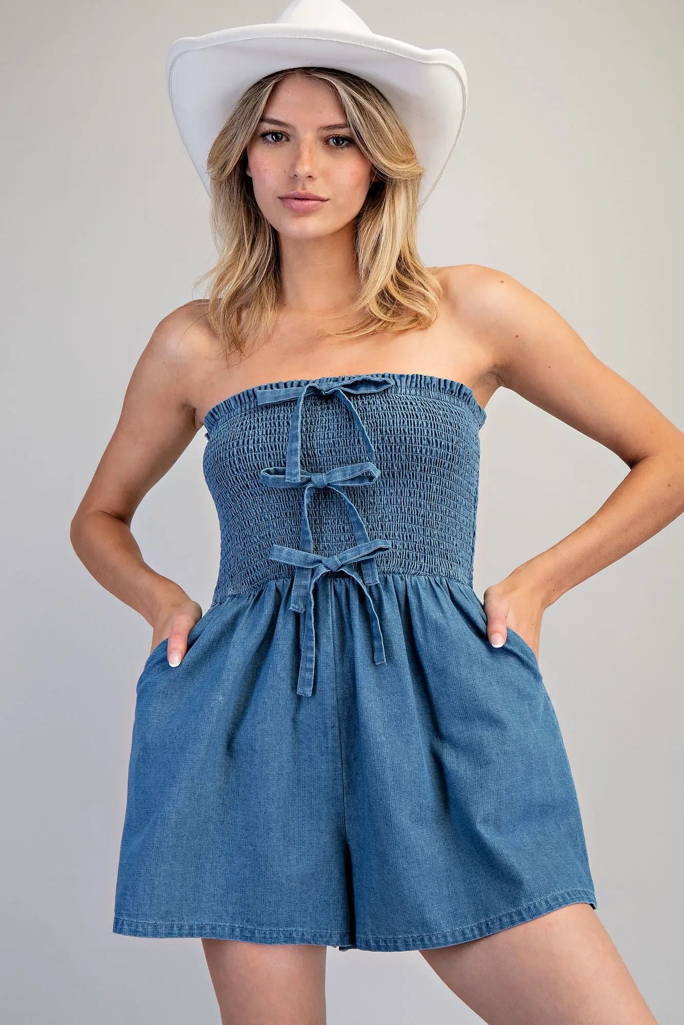 Strapless Front Tie Romper features a smocked bodice with front tie details and relaxed wide-leg shorts