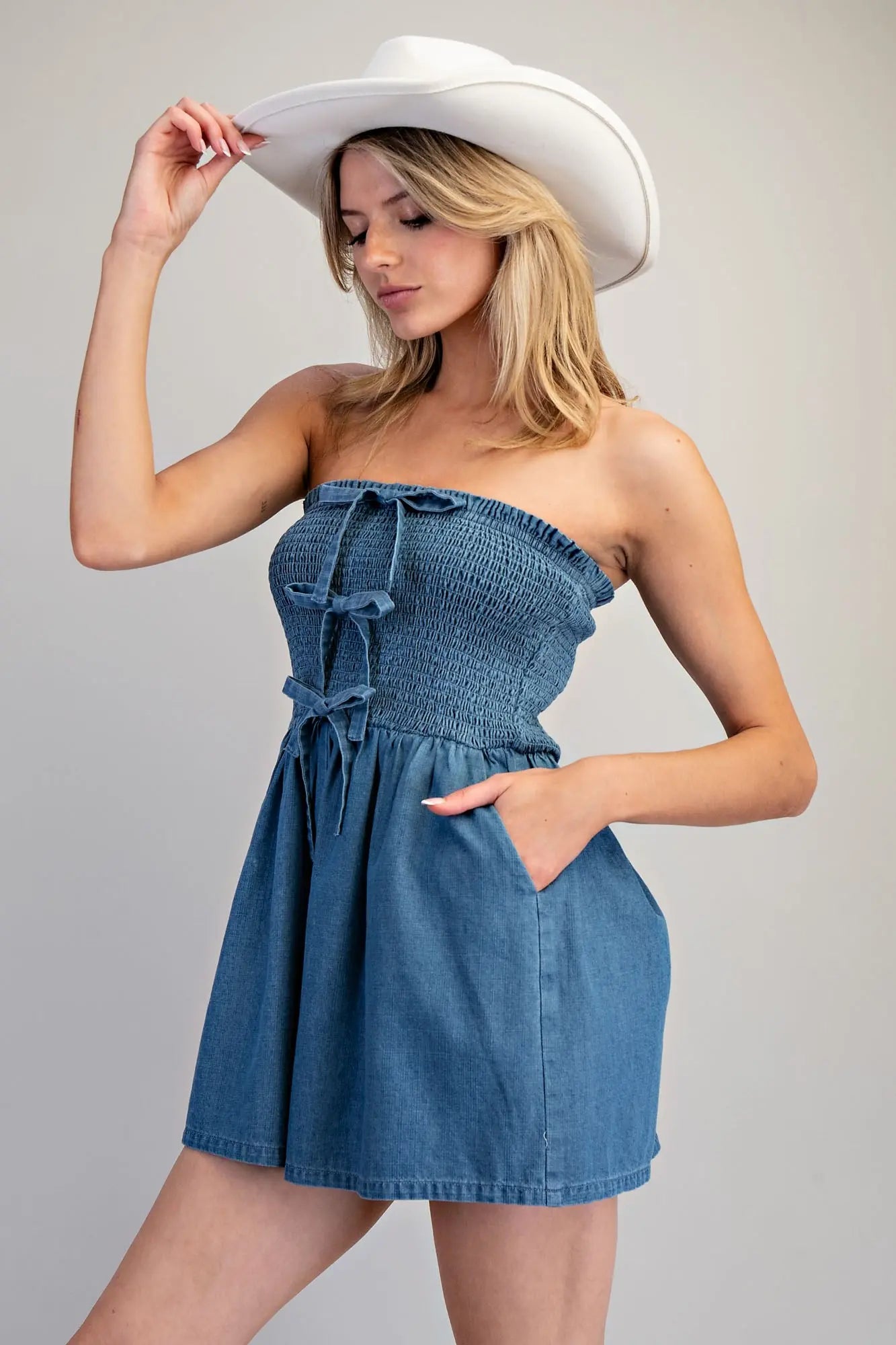 Strapless Front Tie Romper features a smocked bodice with front tie details and relaxed wide-leg shorts