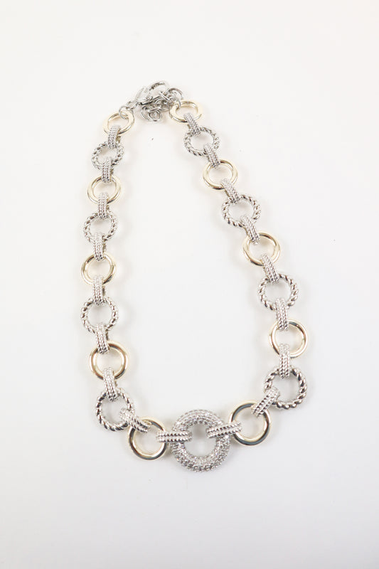 Two-tone gold and silver link statement necklace with textured circular pendant, women’s boutique mixed metal fashion jewelry.