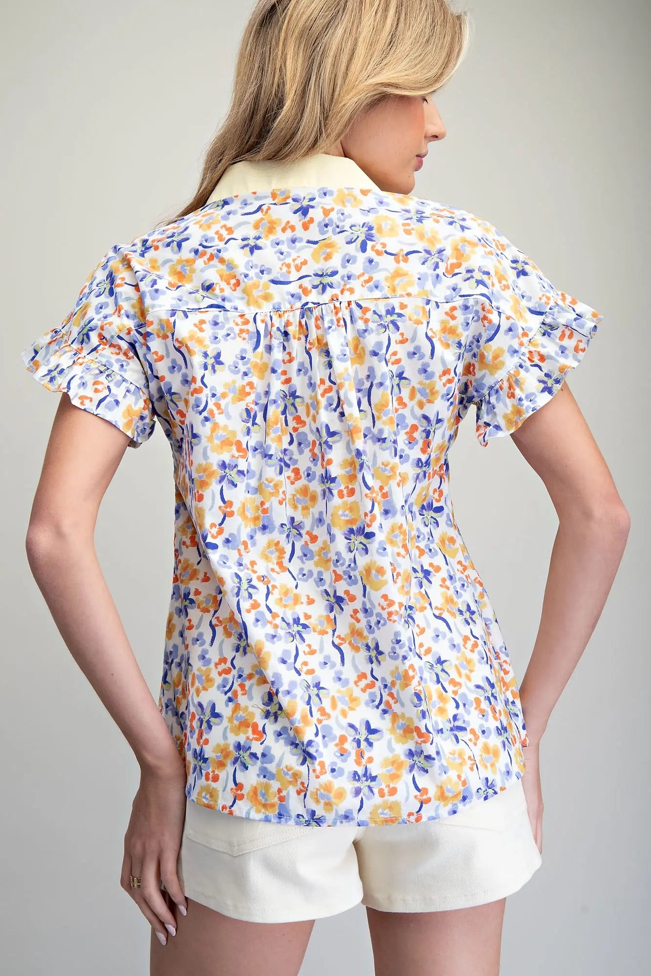 floral button-down blouse featuring flutter sleeves and delicate scalloped trim detailing