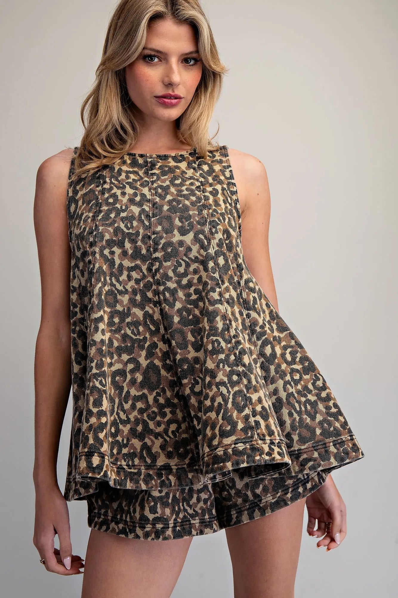 Leopard print sleeveless trapeze top with tiered hem and high crew neckline in cotton denim fabric.