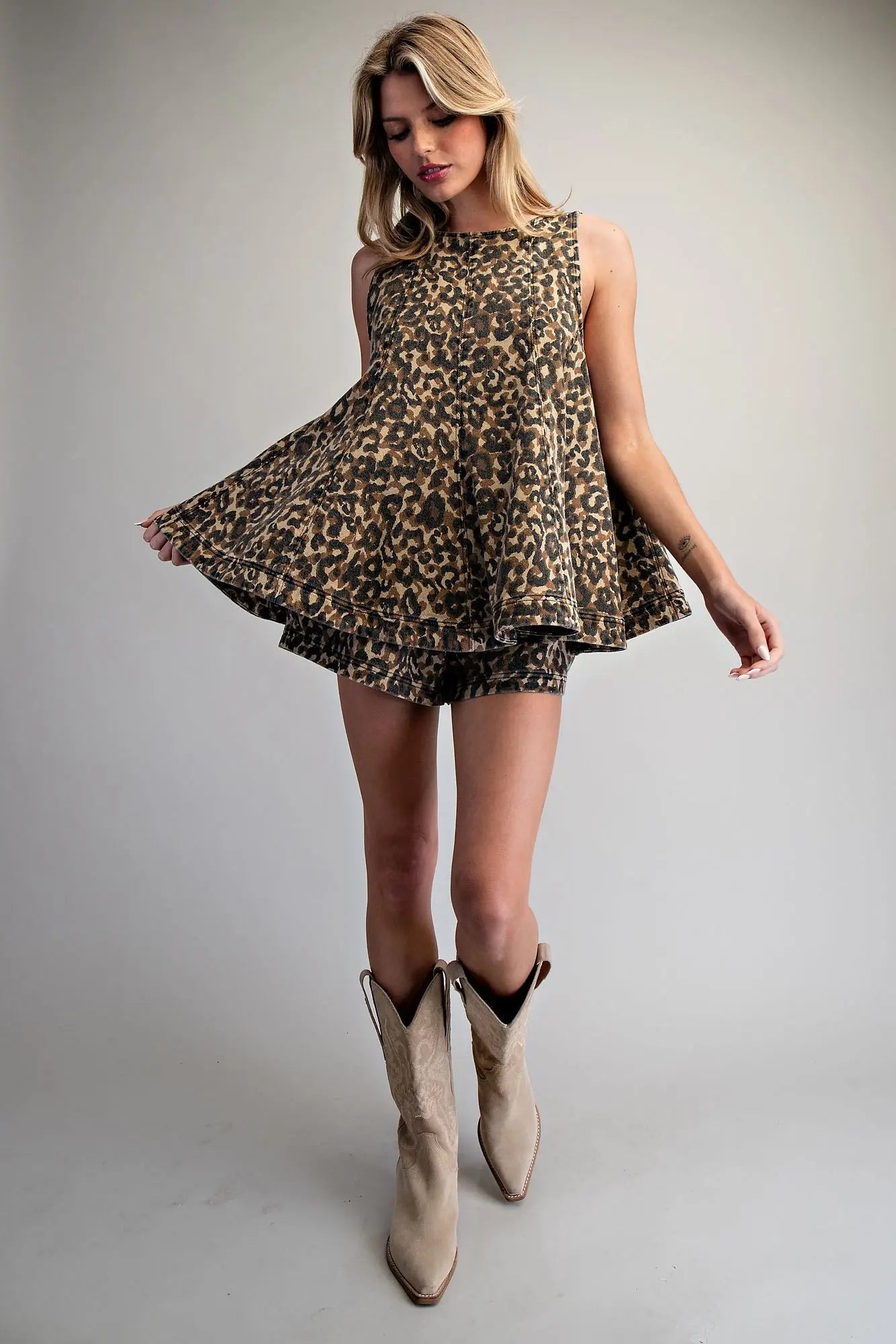 Leopard print sleeveless trapeze top with tiered hem and high crew neckline in cotton denim fabric.