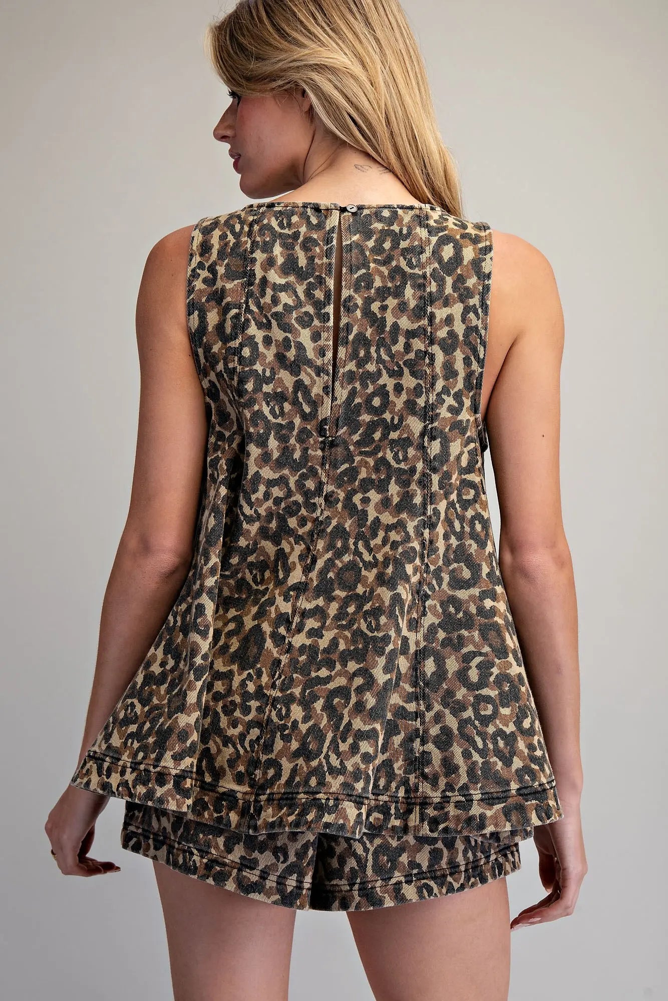 Leopard print sleeveless trapeze top with tiered hem and high crew neckline in cotton denim fabric.