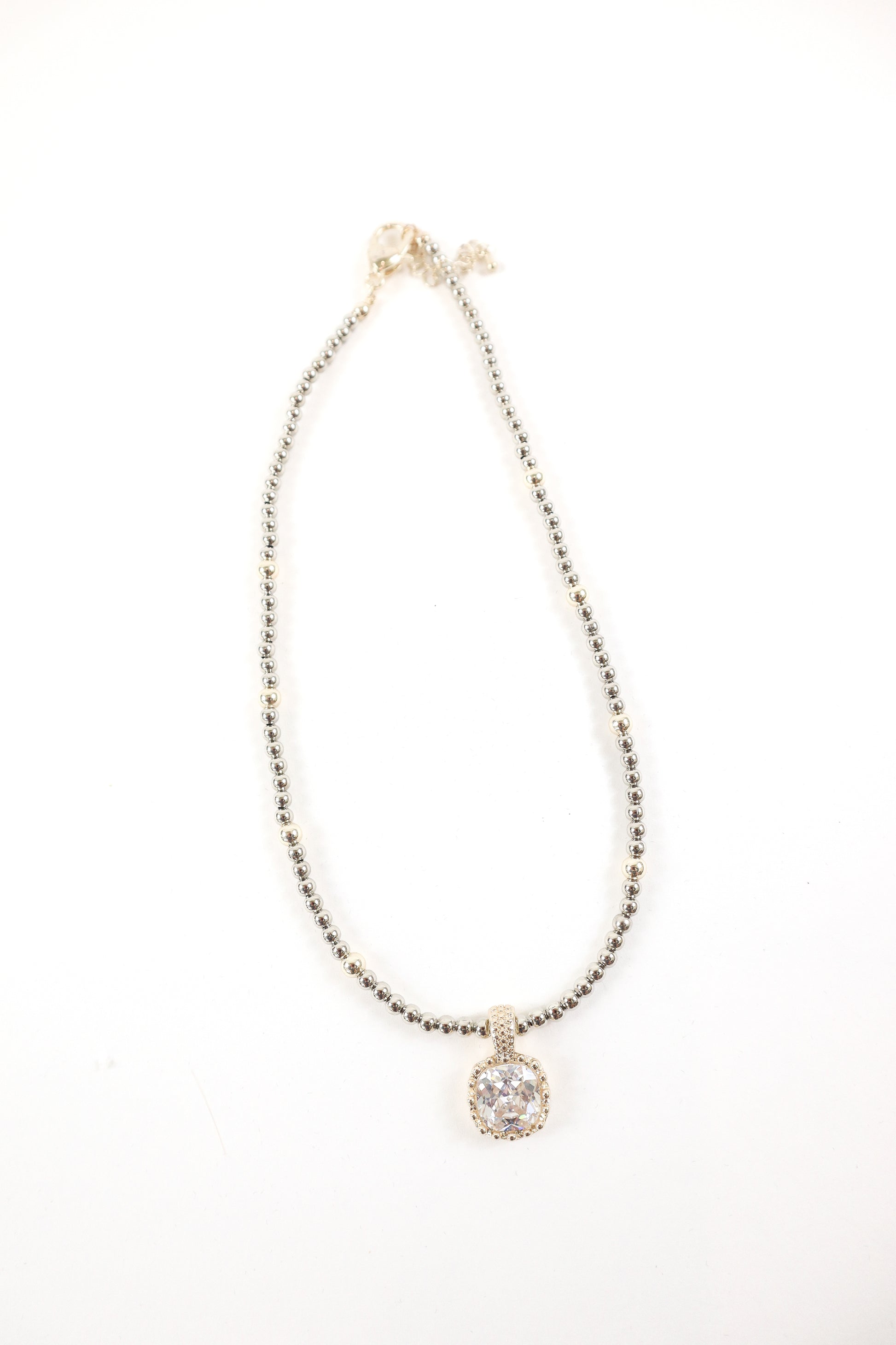 Silver beaded necklace with cushion-cut crystal pendant and pavé detailing, women’s boutique statement jewelry.
