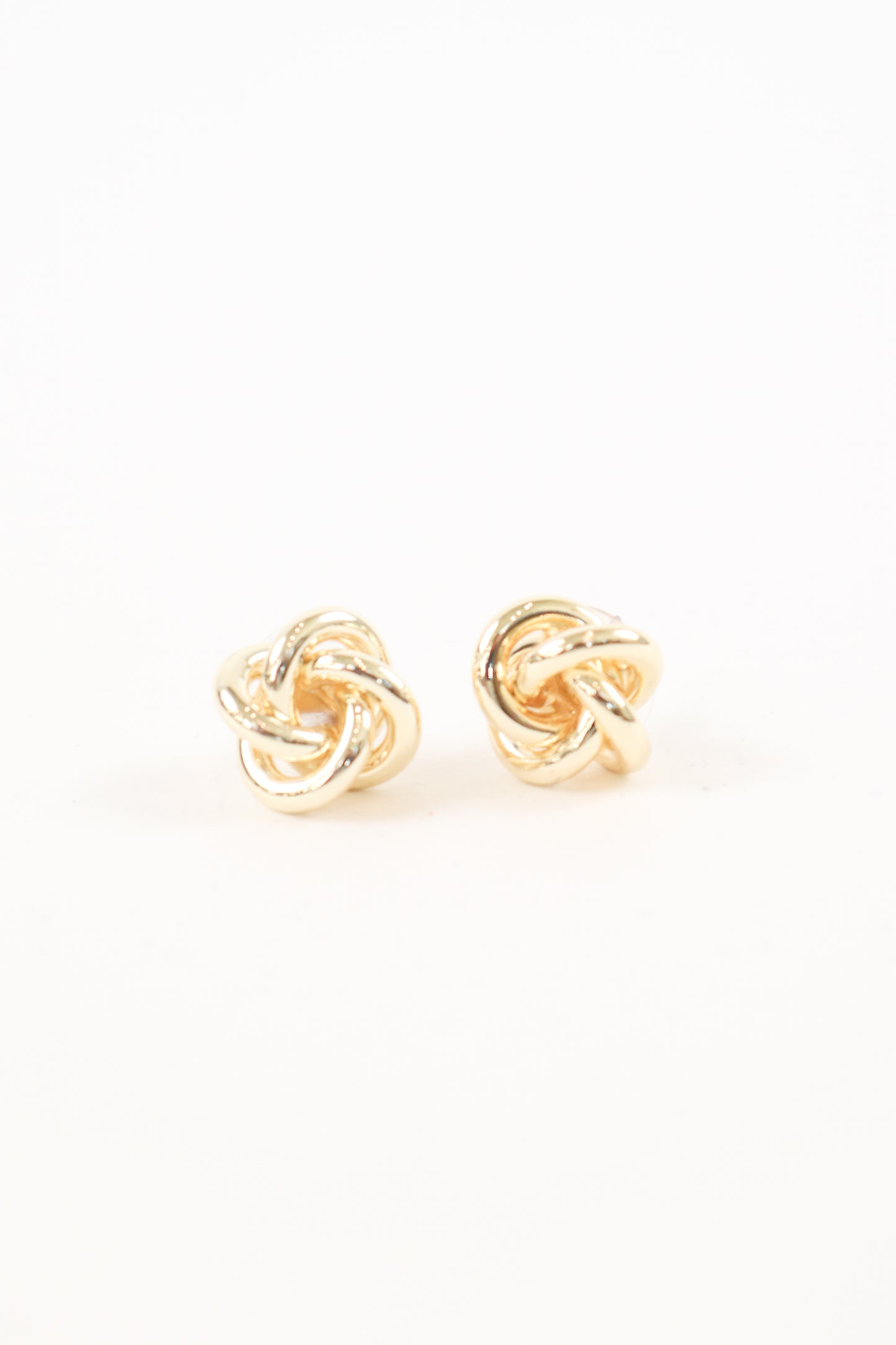 Gold knot stud earrings with polished finish, women’s boutique classic statement jewelry.