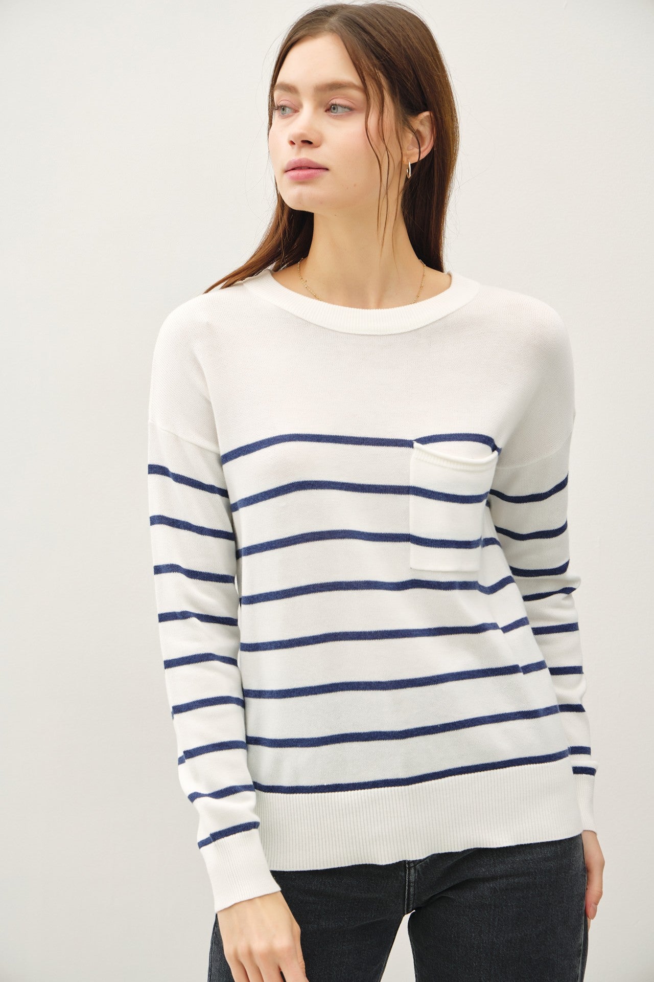 Lightweight striped sweater with round neckline and front pocket.