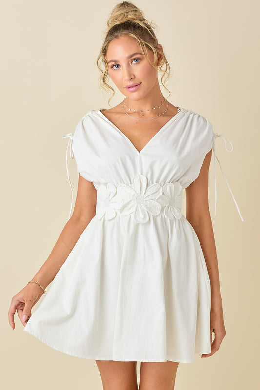 double V-neck dress with embroidered floral appliqué, adjustable tie shoulders, and a flattering smocked waist