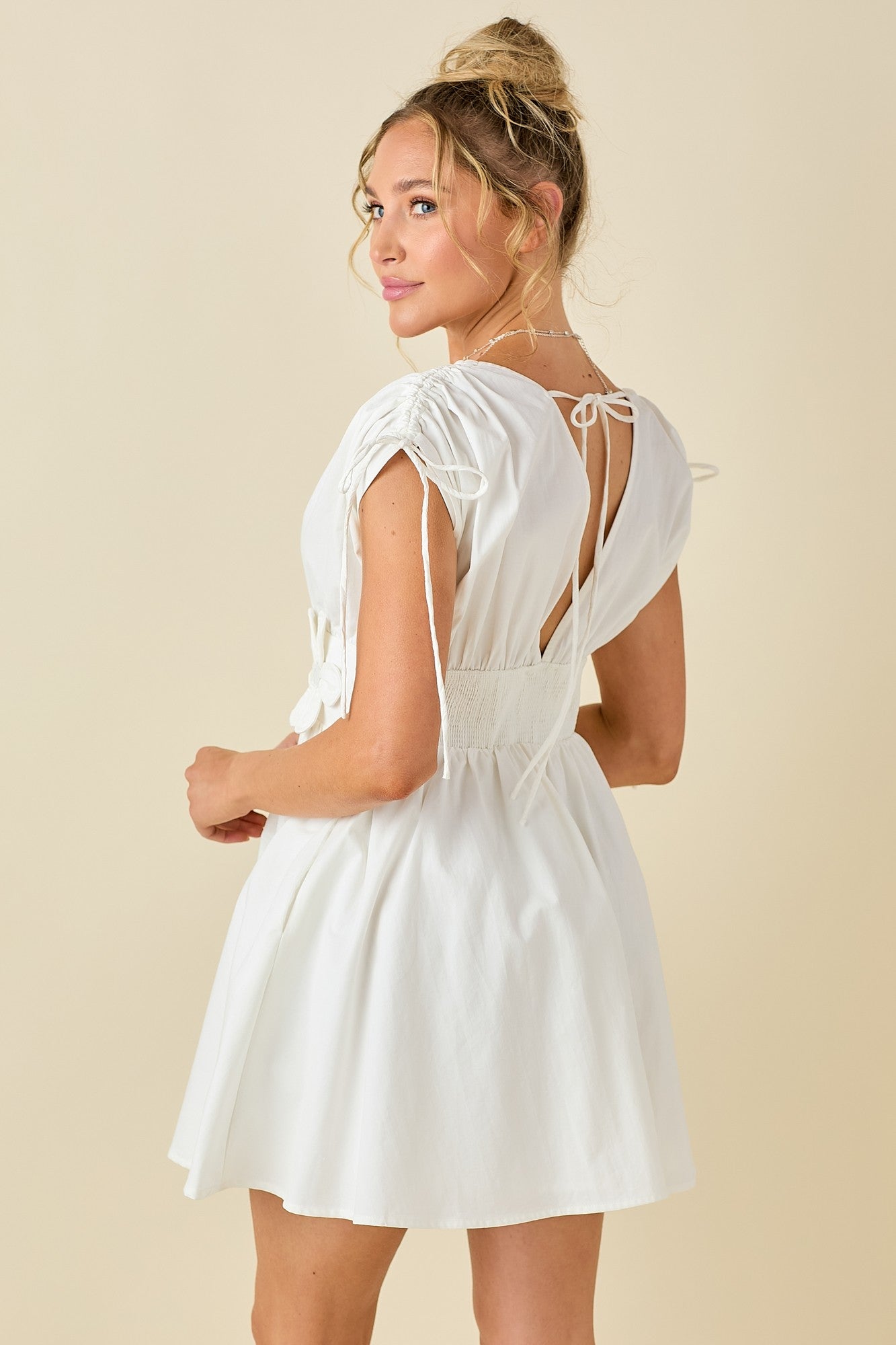 double V-neck dress with embroidered floral appliqué, adjustable tie shoulders, and a flattering smocked waist