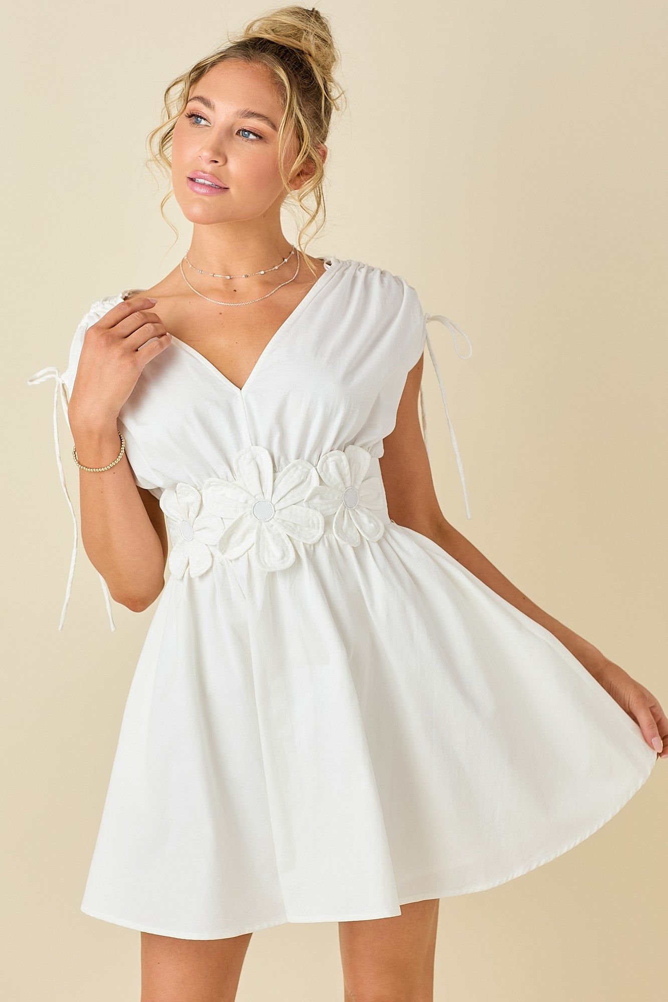 double V-neck dress with embroidered floral appliqué, adjustable tie shoulders, and a flattering smocked waist
