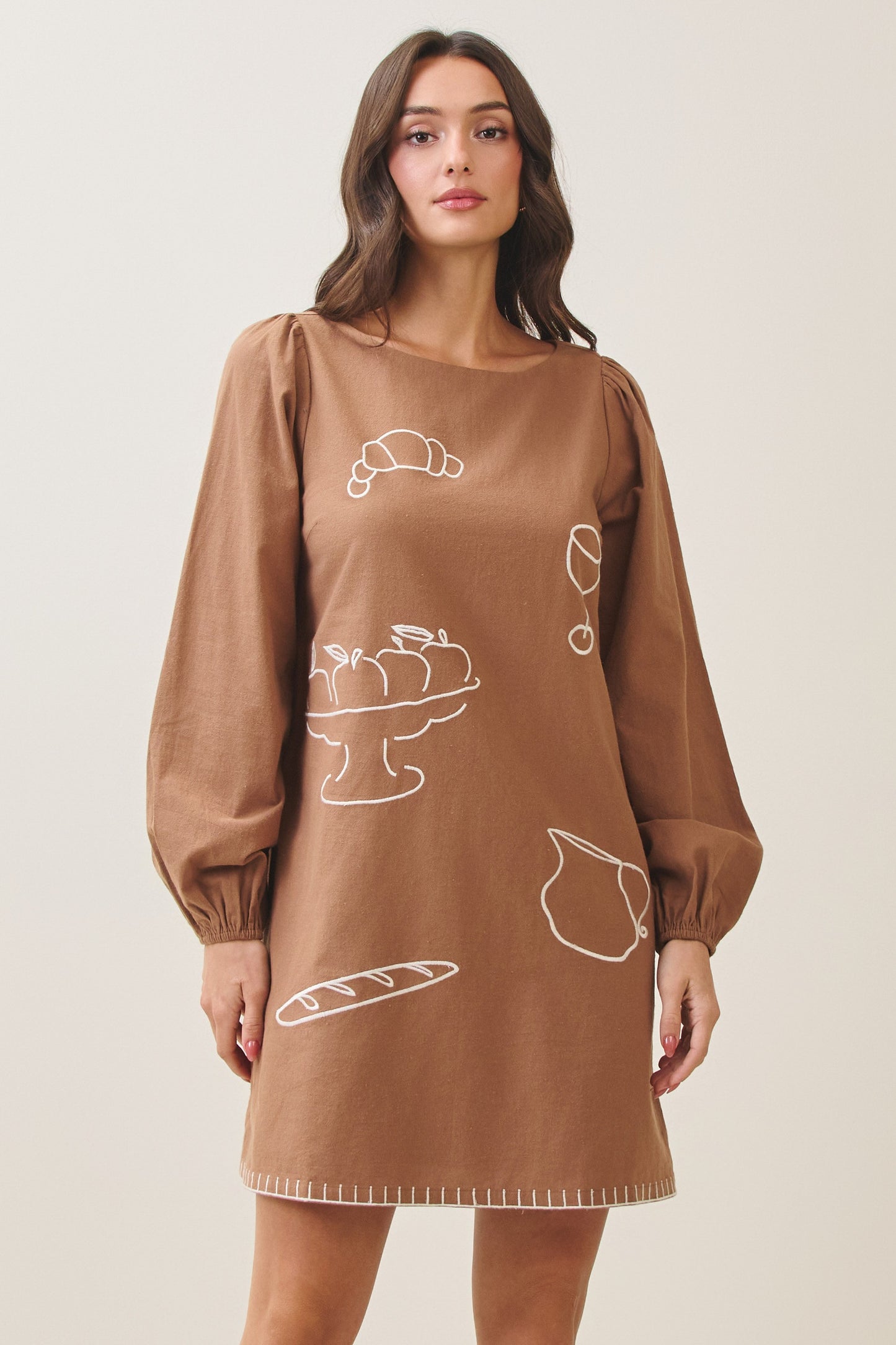 100% cotton embroidered mini dress featuring long volume sleeves, decorative whipstitch detailing, and a relaxed feminine silhouette.