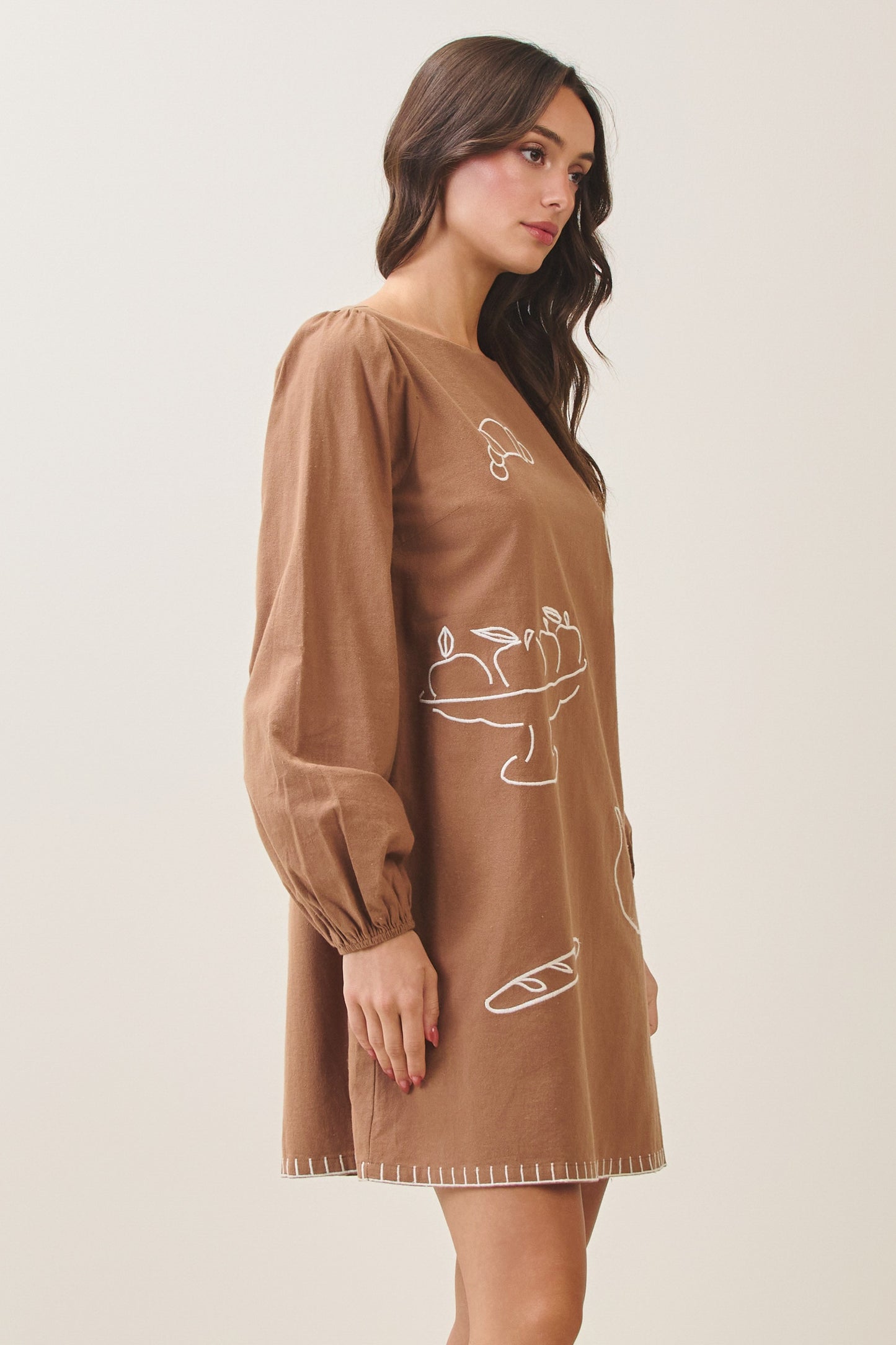 100% cotton embroidered mini dress featuring long volume sleeves, decorative whipstitch detailing, and a relaxed feminine silhouette.