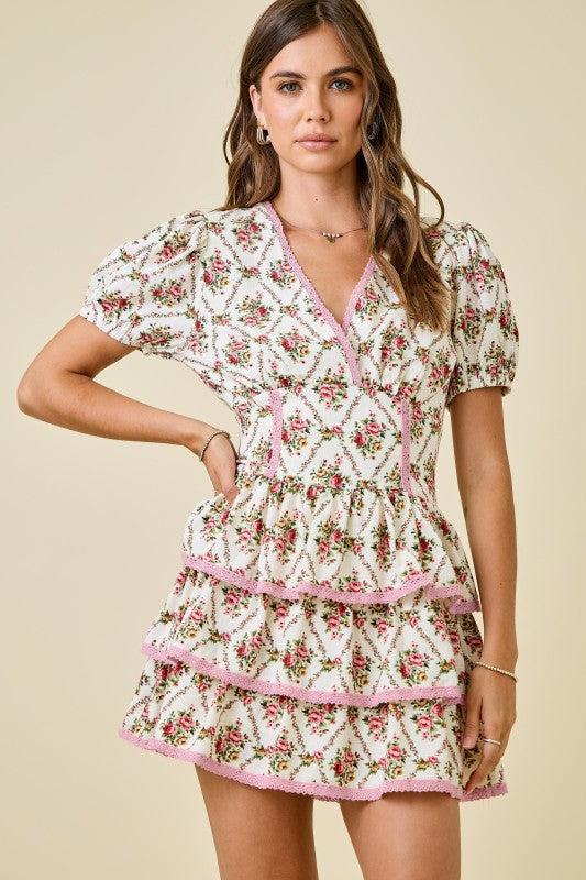 The Isolde Floral Lace Ruffle Romper Dress combines playful charm with romantic lace accents.