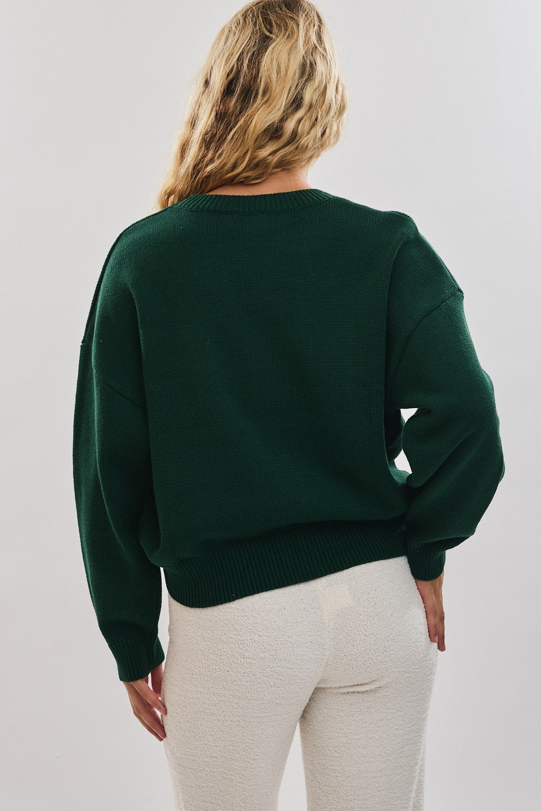 Spread cozy holiday cheer in this playful sweater featuring a festive cocoa mug motif.